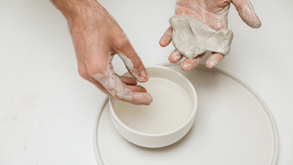 a hand holding a clay