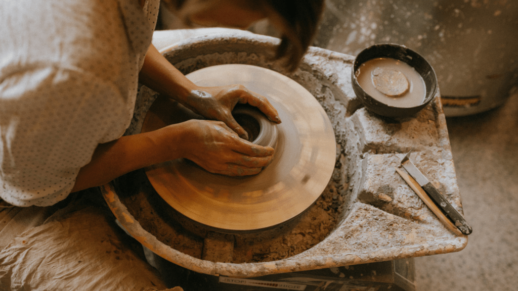 a woman doing a clay jar sculpture