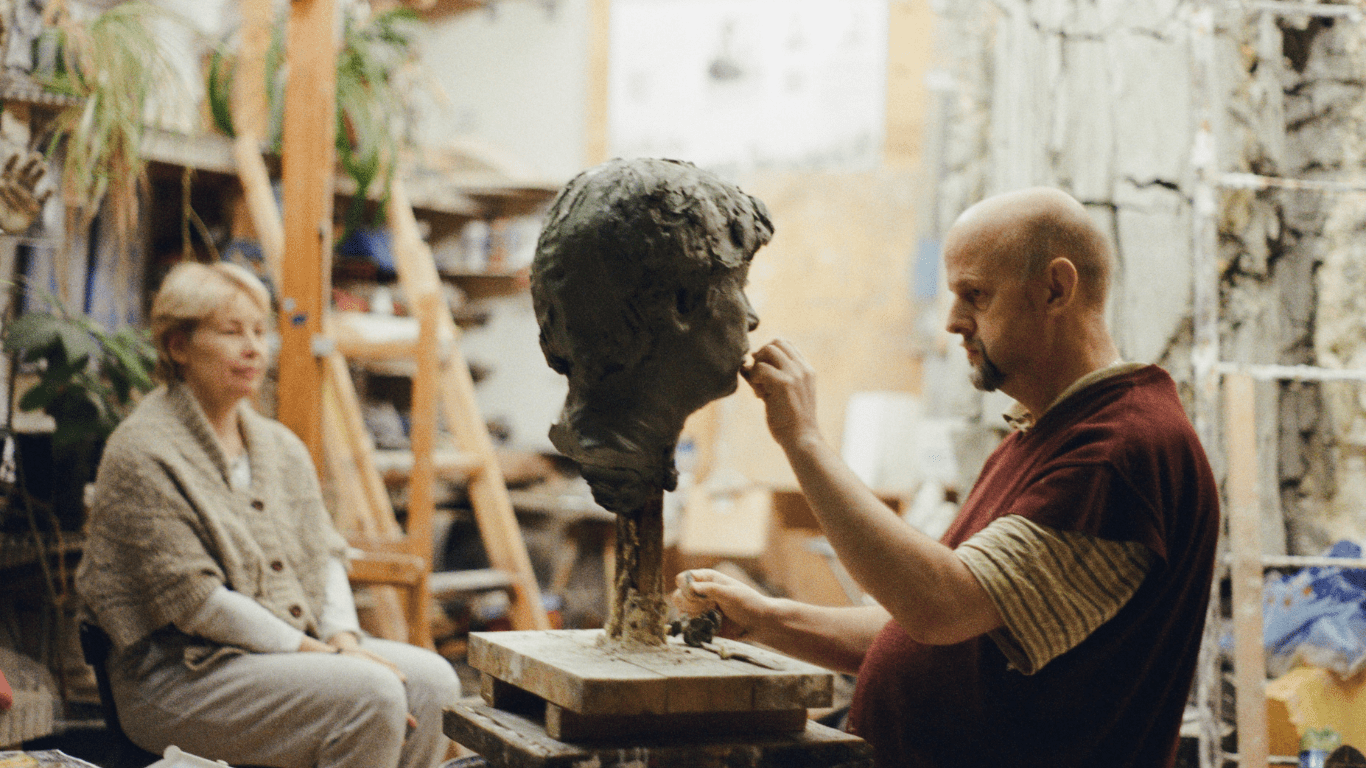 a man sculpting a head through an imagery of a woman