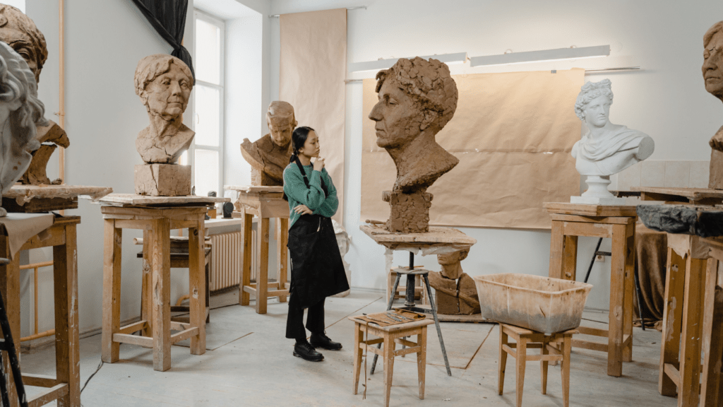 a sculptor in a room full of sculptures