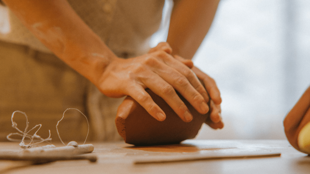 a hand molding a clay