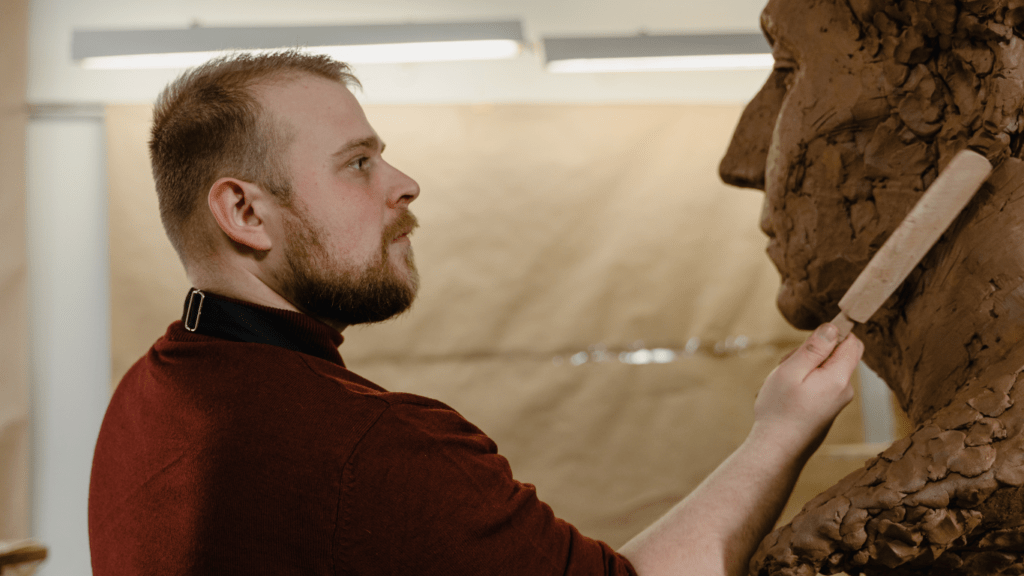 a man sculpting a human figure