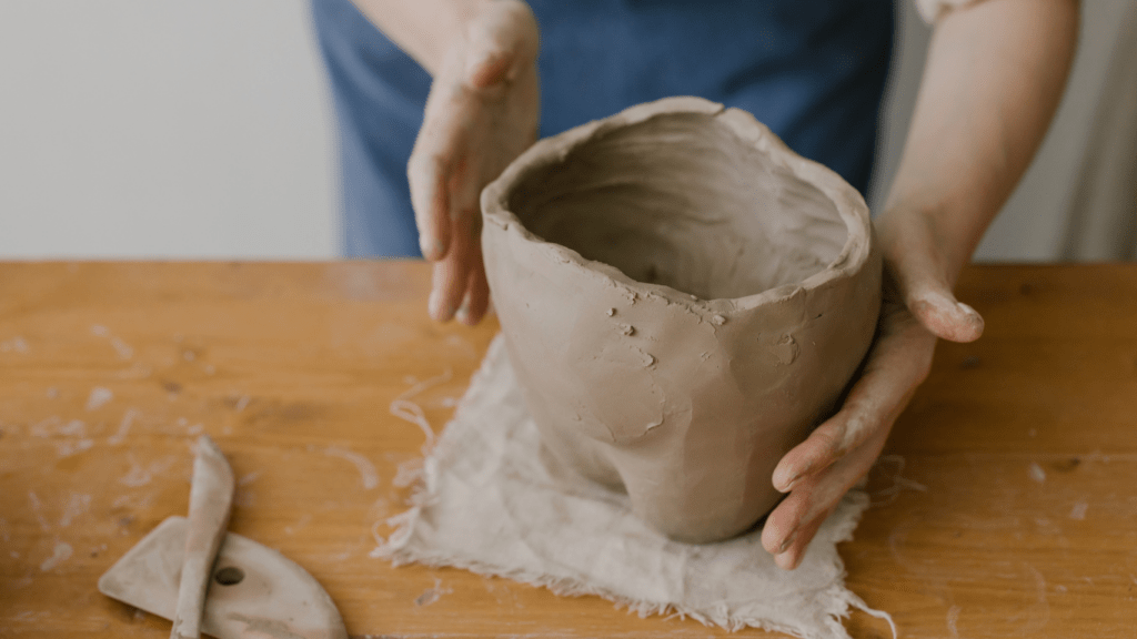 a man using a clay in sculpting