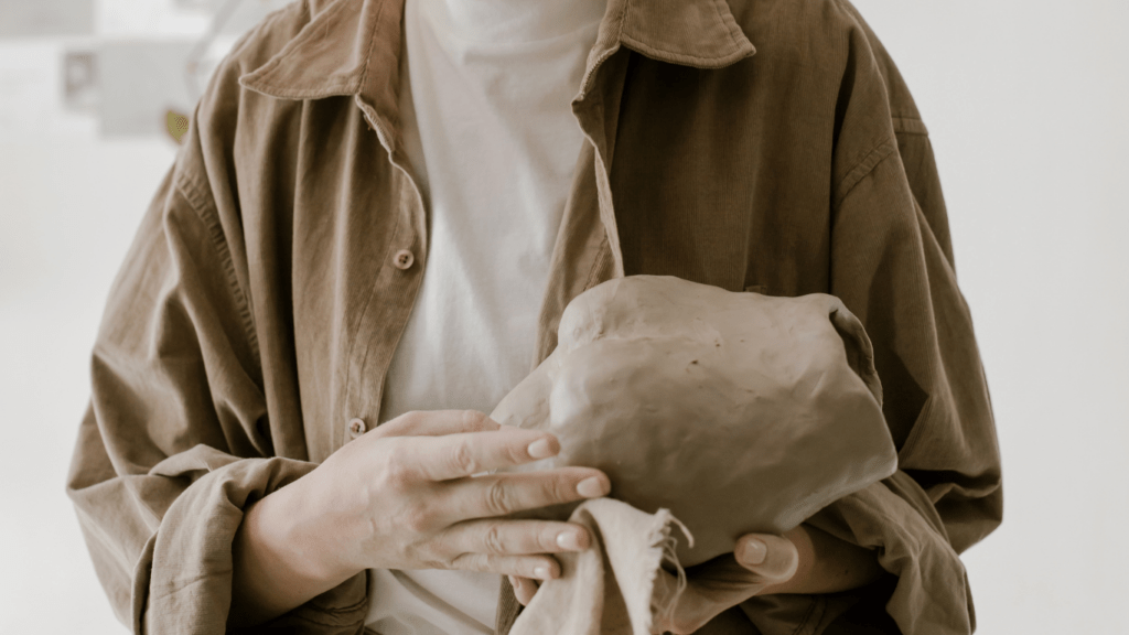 a man using clay material in sculpting