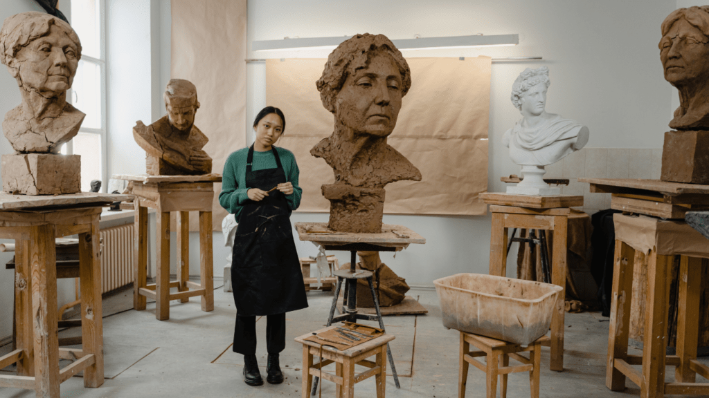 a woman sculptor in a room of sculptures