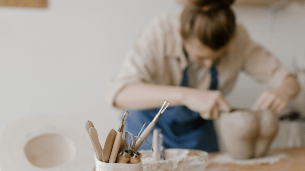 a woman using clay in sculpting